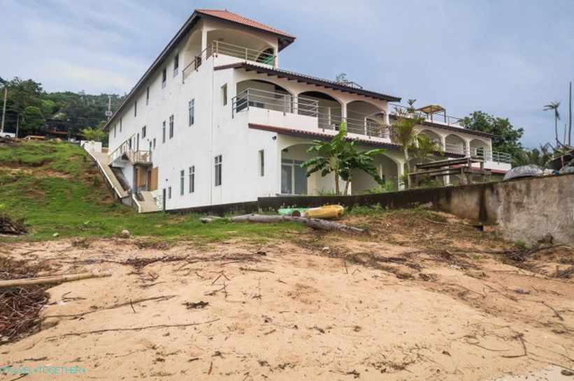Pogled s plaže na stranu staklene kućice i odmarališta Baan Jaidee
